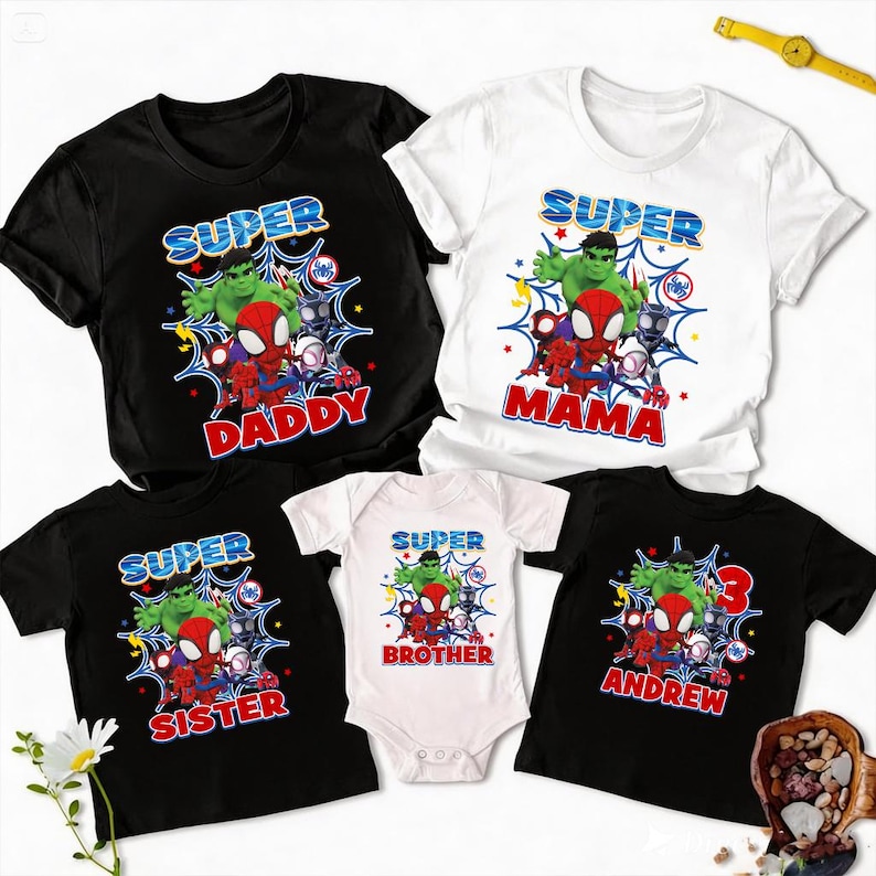 May include: A collection of superhero-themed t-shirts and a onesie. The shirts are black and white, featuring the words "SUPER" and "DADDY", "MAMA", "SISTER", "BROTHER", and "ANDREW". Each shirt has a graphic of Spider-Man, Hulk, and other characters.