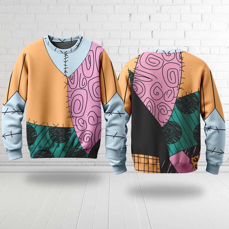 Op de afbeelding: Een crewneck sweatshirt met een patchwork ontwerp met oranje, lichtblauwe, roze en groene panelen. Het ontwerp bevat gestikte naden en een verscheidenheid aan patronen, waaronder krullen en stippen. Het sweatshirt wordt van voor en achter getoond.