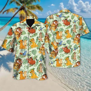 May include: A short-sleeved button-down shirt featuring a repeating pattern of cartoon characters from The Lion King, including Simba, Timon, Pumbaa, and Zazu, set against a light green background with tropical leaves. The shirt is displayed on a beach.