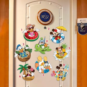 May include: A collection of colorful Disney-themed door decorations featuring characters like Donald Duck and Mickey Mouse in summer attire. Each decoration includes a name, such as "Asheep" or "Quentin", and is designed for a cruise ship door.