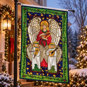 May include: A rectangular garden flag featuring a stained glass style illustration of a central angel with large white wings playing a golden harp, flanked by two smaller angels playing a violin and a lute, all framed by green ivy and red berries.