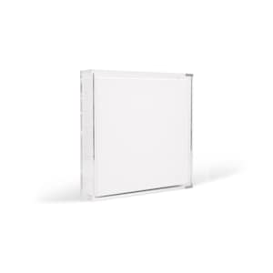 May include: A square, clear acrylic display box featuring a transparent frame and a solid white interior panel. The object has a clean, geometric design with visible corner joints and a smooth, reflective surface on all sides of the outer casing.