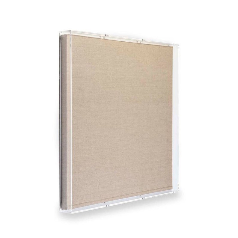 Puede incluir: Una obra de arte de lienzo beige enmarcada en un marco de acr&iacute;lico transparente.