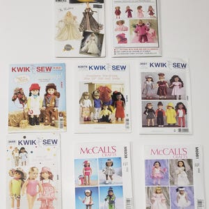 May include: A collection of eight sewing patterns for doll clothing, including Simplicity, Kwik Sew, and McCall's brands. The envelopes feature illustrations and photographs of dolls wearing various outfits, such as wedding gowns, winter gear, and casual wear.