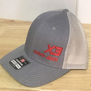 Puede incluir: Gorra de camionero de malla gris y blanca con un logotipo bordado en rojo que dice "Can-Am X3".