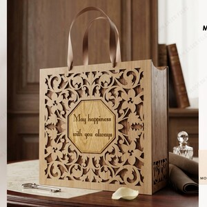 May include: A rectangular wooden gift bag with intricate laser-cut floral patterns and two brown ribbon handles. The center features an octagonal panel with the engraved text "May happiness with you always". The design is compatible with 3mm material.