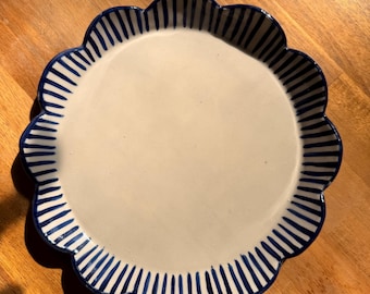 Plato llano o de ensalada de inspiración francesa con rayas azules y bordes festoneados pintados a mano.