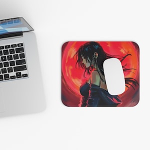 Op de afbeelding: Een rechthoekige muismat met een anime-stijl illustratie van een vrouw met lang zwart haar tegen een rode achtergrond. Een witte computermuis ligt op de mat. Het kunstwerk heeft een digitale schilderstijl.