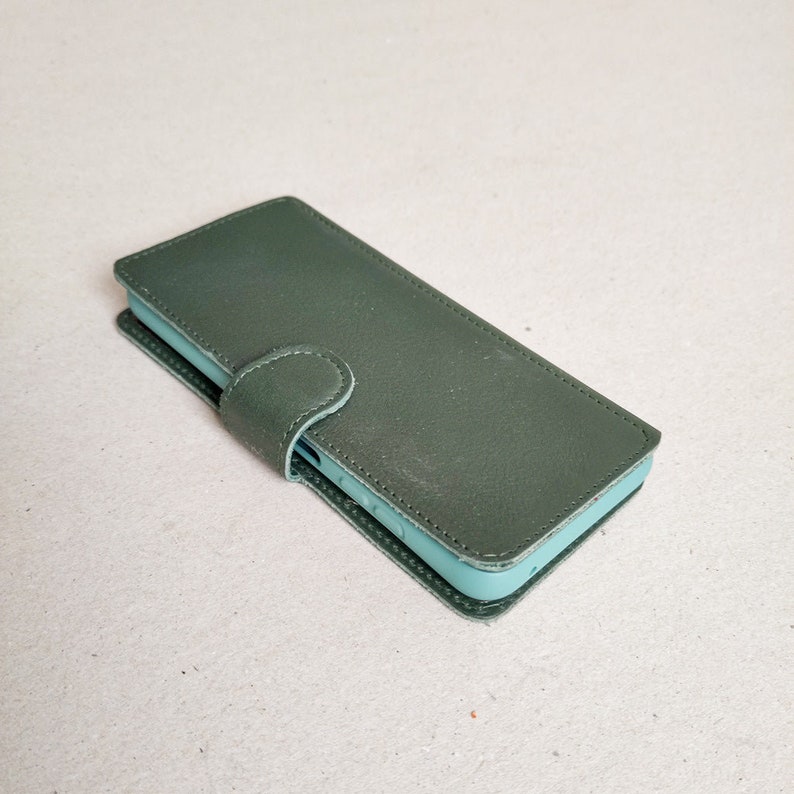 a dark green sustainable leather flip-cover for the fairphone4 with a light green protective case, which protects the edges