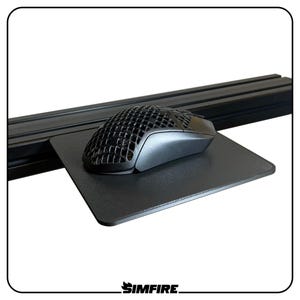 May include: A black gaming mouse with a honeycomb design sits on a black mousepad. The mousepad is rectangular and placed on a black, horizontal bar. The SIMFIRE logo is in the bottom right corner.