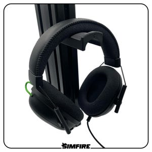 Op de afbeelding: Zwarte over-ear hoofdtelefoon met een gewatteerde hoofdband en oorschelpen. De hoofdtelefoon heeft een groene accentkleur en is verbonden met een zwarte kabel. De merknaam "SIMFIRE" staat onderaan.