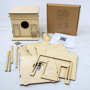 May include: A DIY birdhouse kit with unfinished wooden components. The kit includes pre-cut pieces for assembly, a partially assembled birdhouse, a cardboard box with text, and instructions. The birdhouse has a round entry hole and two small doors.
