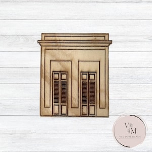 May include: A wooden cutout of a building with two windows and a simple design. The windows have shutters and are rectangular. The building is light brown and has a white background.