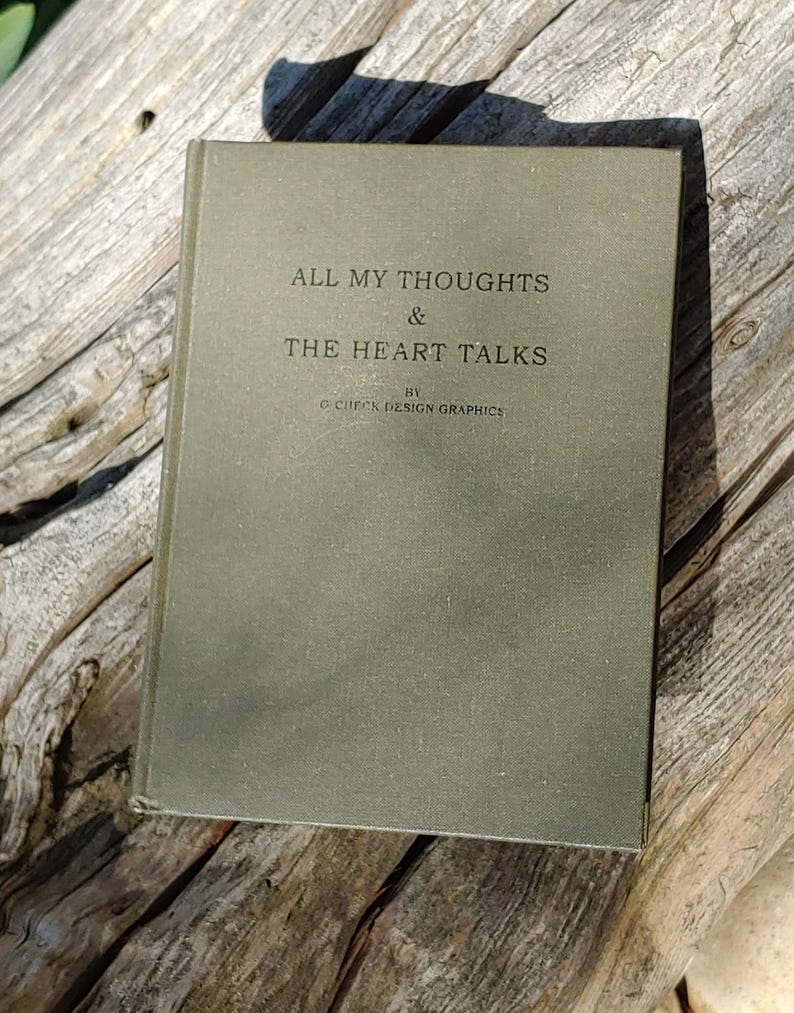 Puede incluir: Un libro antiguo con una cubierta verde apagada, titulado "ALL MY THOUGHTS & THE HEART TALKS" por C. CHICK DESIGN GRAPHICS. El libro descansa sobre una superficie de madera envejecida, con el t&iacute;tulo en una fuente simple y elegante.