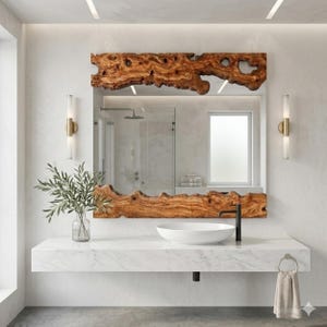 May include: A rectangular mirror with a natural wood frame, showcasing a unique, organic edge. The mirror is mounted above a white marble vanity with a white sink and black faucet. The bathroom features a modern design with neutral tones.