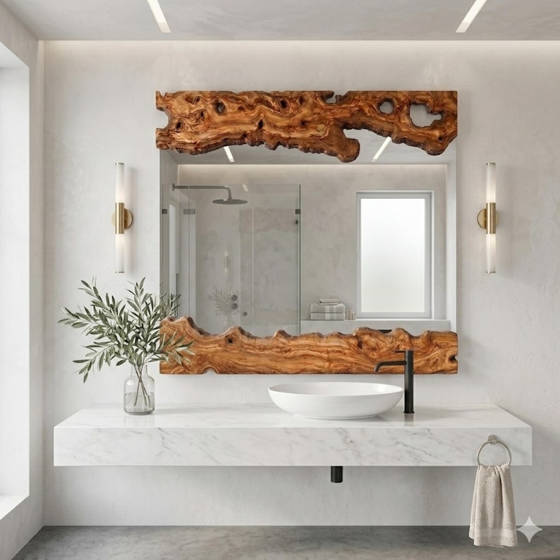 May include: A rectangular mirror with a natural wood frame, showcasing a unique, organic edge. The mirror is mounted above a white marble vanity with a white sink and black faucet. The bathroom features a modern design with neutral tones.