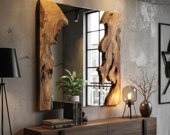 May include: A rectangular mirror with a natural wood frame. The frame has a unique, organic shape with a light brown color. The mirror is mounted on a dark brown wooden cabinet. A black lamp and a small table lamp are on either side of the mirror.