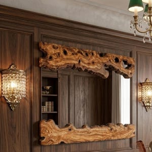 May include: A rectangular mirror with a natural wood frame, mounted on a dark wood paneled wall. The frame has a unique, organic shape with knots and holes. Two ornate sconces flank the mirror, and a chandelier is visible.