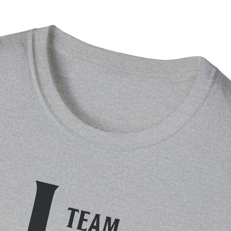 A close-up shot of the neckline of a light gray heather t-shirt with dark text visible near the bottom edge.