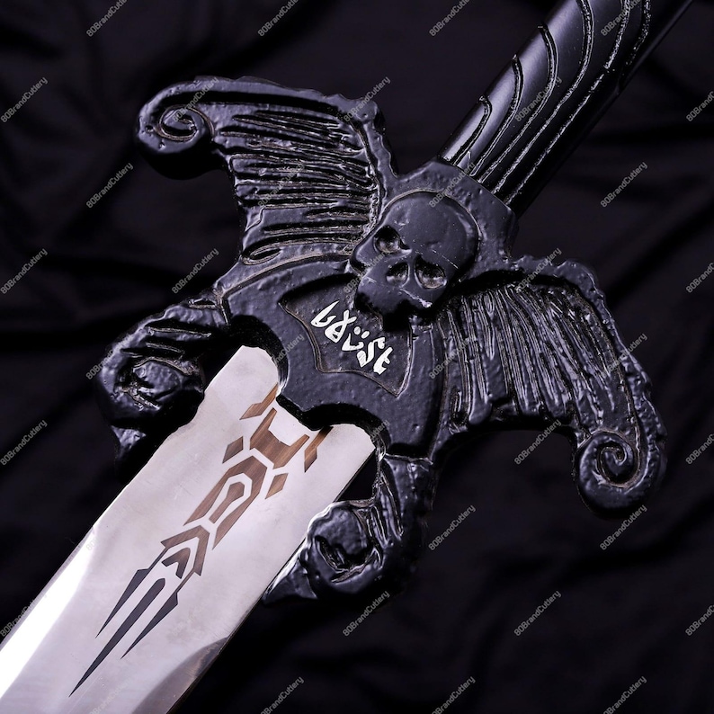May include: A black sword with a skull and wing design on the hilt. The blade is silver with a brown and black pattern. The word "baust" is written in white on the hilt.