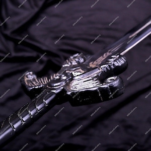May include: A black sword with a detailed dragon-shaped hilt. The blade is silver and the handle is wrapped in a textured pattern. The sword is set against a dark background, highlighting its intricate design.