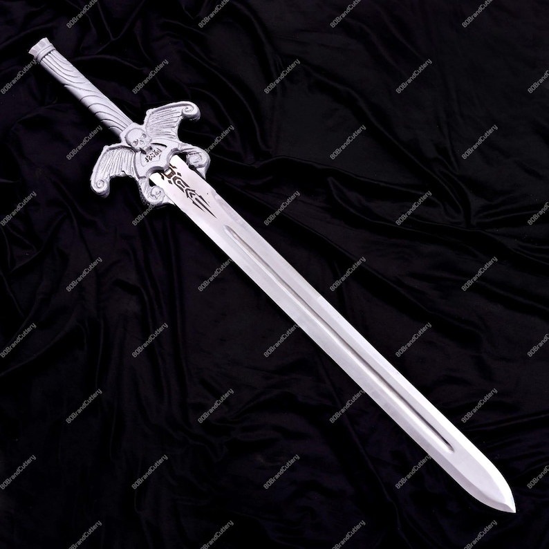 May include: A silver-colored sword with a detailed hilt featuring wings and a skull design. The blade is long and straight, with a pointed tip. The sword is displayed against a black background.