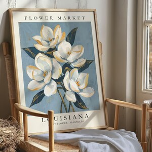 Louisiana Flower Market poster featuring the state flower Magnolia, elegant white blossoms with golden highlights and deep green leaves against a soft blue textured background in vintage botanical art style.