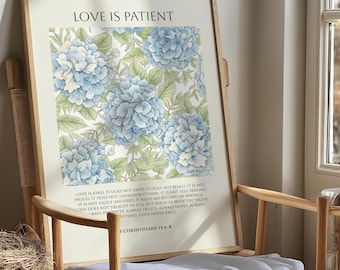 May include: A framed print featuring a floral design of blue hydrangeas and green leaves. The text "LOVE IS PATIENT" is at the top, with a Bible verse below. The print is displayed on a wooden chair.