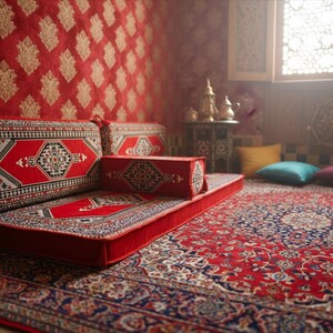 May include: A red and black patterned rug and cushions create a cozy seating area. The cushions and rug feature geometric designs. The room has a red patterned wall and a decorative window.