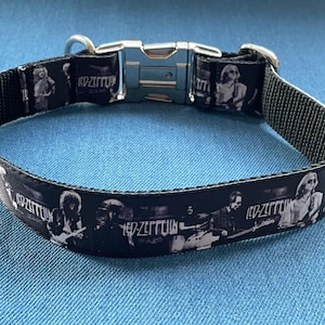 May include: Black dog collar with a silver buckle and a black and white print of the band Led Zeppelin. The print features the band members and the band's name.