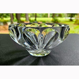 May include: A clear, heavy-duty glass bowl featuring a series of deep, vertical, fan-shaped indentations around the exterior. The bowl has a smooth, circular rim and a thick, solid base, creating a reflective, multi-faceted appearance throughout.