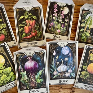 May include: A collection of eight illustrated cards featuring various vegetables. Each card has a black border with gold accents and a unique illustration of tomatoes, peppers, peas, beans, lettuce, onions, garlic, and a pumpkin. The cards have text labels.