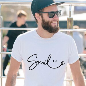 May include: A white t-shirt with the word "Smile" written in a cursive font with a smiley face at the end of the word.