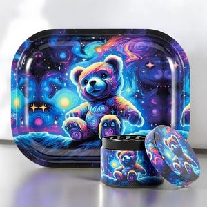 Pode incluir: Uma bandeja retangular e um triturador de ervas cilíndrico a condizer com um design cósmico vibrante e colorido. A arte apresenta um urso de peluche sentado entre padrões de nebulosas rodopiantes em tons de azul, roxo, rosa e laranja.