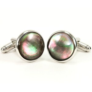 May include: A pair of silver cufflinks with round, iridescent black, green, and pink mother-of-pearl insets.