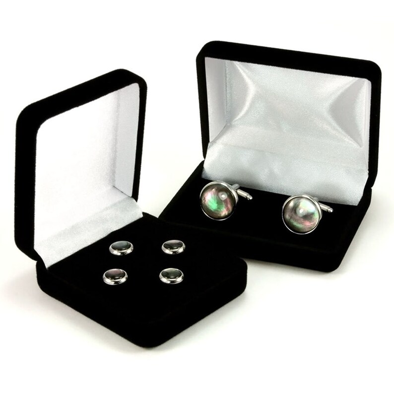 May include: A set of four black and silver cufflinks and four black and silver shirt studs in velvet boxes.