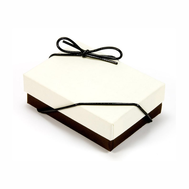 May include: A white gift box with a brown bottom and a black ribbon tied in a bow.
