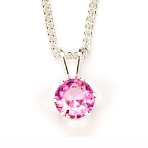 May include: A silver chain necklace with a pink gemstone pendant.