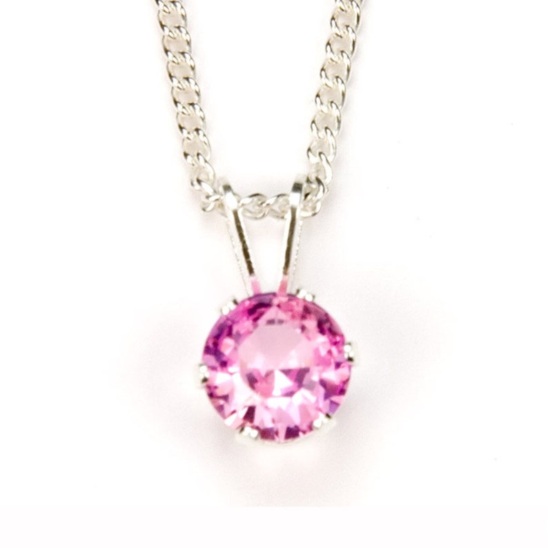 May include: A silver chain necklace with a pink gemstone pendant.