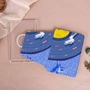 May include: A rectangular protective case for an e-reader featuring a graphic illustration of a swimming pool at night. The design includes a yellow moon, a diving board, and swimmers in blue water. The text reads midnight swim is back.