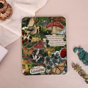 Op de afbeelding: Een decoratief rechthoekig item met een collage van paddenstoelen, vlinders en tekst. De tekst luidt "you are my favorite" en "Someday, we will find what we are looking for. Or maybe not. Maybe we'll find something much greater than that."