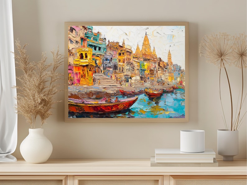 May include: A colorful painting of a cityscape with buildings and boats on a river. The buildings are painted in shades of yellow, orange, red, and blue. The boats are painted in shades of red, orange, and yellow. The river is painted in shades of blue and green.