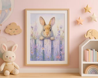 Könnte beinhalten: Ein gerahmtes Aquarellbild eines braunen Kaninchens, das über einen lila Lattenzaun mit Blumen schaut. Das Kaninchen hat weißes Fell um Gesicht und Ohren. Der Hintergrund ist ein hellblauer Aquarell-Wasch.