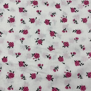 Può includere: Tessuto bianco con un motivo ripetuto di piccoli fiori rosa e foglie verdi. Il design floreale è sparso sul tessuto, creando un'estetica delicata. Il tessuto sembra essere cotone o un materiale leggero simile.