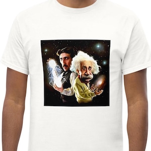 May include: A white t-shirt featuring a graphic print of Nikola Tesla and Albert Einstein standing back-to-back against a dark starry space background. Tesla holds a glowing electrical orb, while Einstein holds a swirling galaxy in his hands.