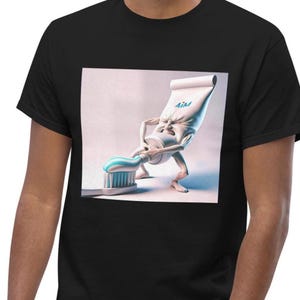 Op de afbeelding: Een zwart t-shirt met een grafische print van een antropomorfe tandpastatube met armen en benen, die zich inspant om blauw-wit gestreepte tandpasta op een tandenborstel te knijpen. De tube is voorzien van de tekst AiM in blauwe letters.