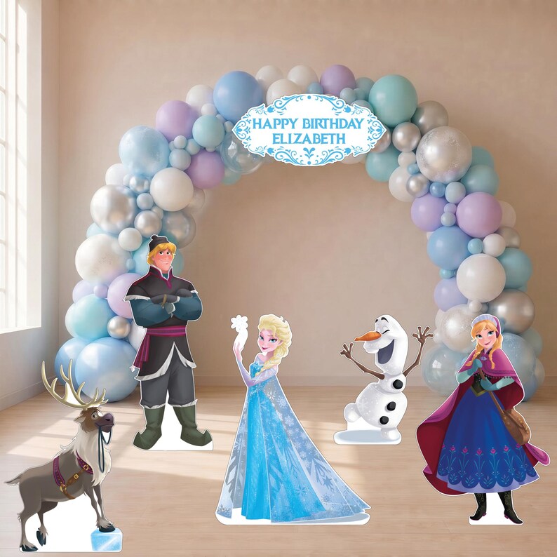 May include: A balloon arch in shades of blue, purple, white, and silver with a central sign reading HAPPY BIRTHDAY ELIZABETH. Standing in front are cardboard cutouts of a reindeer, a man in a dark tunic, a blonde woman in a blue dress, a snowman, and a woman in a purple cape.