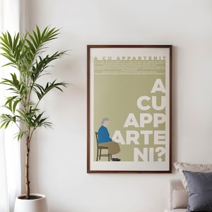 Può includere: Una stampa artistica incorniciata con un design minimalista. L'opera presenta una figura seduta in blu e beige, con il testo "A CU APPARTENI?" in grandi lettere bianche. Una pianta in vaso è in primo piano.
