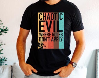May include: Black t-shirt with the text "CHAOTIC EVIL WHERE RULES DON'T APPLY" in a rectangular design. The design includes a dragon illustration and a color block of yellow, red, brown, and teal. The shirt is short-sleeved.