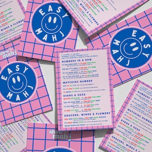 May include: Pink cards with a blue grid pattern and the words "EASY MAHJ" in a blue circle with a smiley face. The cards have text about numbers, matching, and dragons.